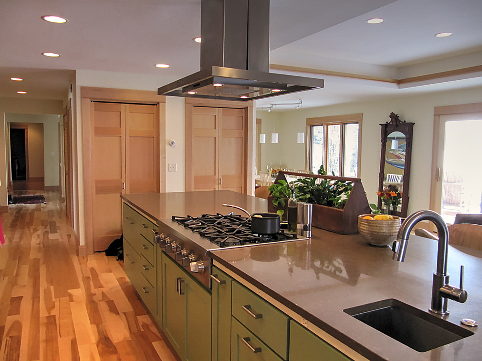 Inspiration for a mid-sized transitional galley light wood floor kitchen remodel with quartz countertops, glass tile backsplash, stainless steel appliances, an undermount sink, shaker cabinets, green cabinets, green backsplash and an island