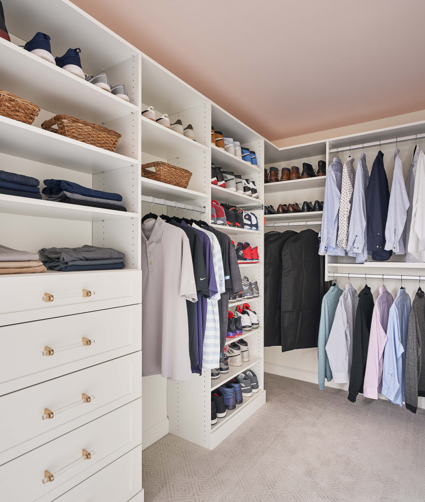 Large beach style gender neutral walk-in wardrobe in Charlotte with shaker cabinets, white cabinets, carpet and beige floors.