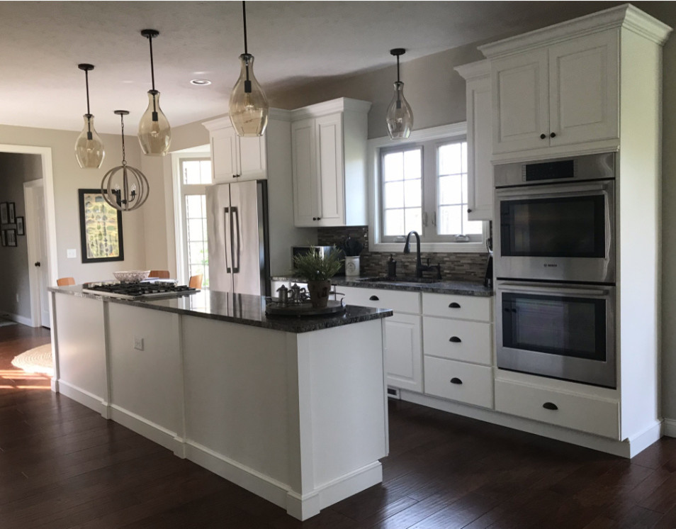 Eat-in kitchen - mid-sized transitional galley dark wood floor and brown floor eat-in kitchen idea in Cleveland with an undermount sink, raised-panel cabinets, white cabinets, granite countertops, multicolored backsplash, mosaic tile backsplash, stainless steel appliances and an island