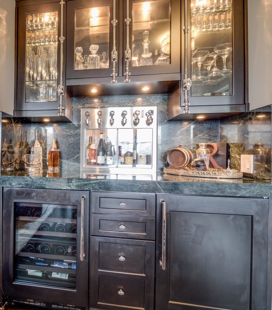 Photo of a mid-sized transitional single-wall wet bar in New York with no sink, black cabinets, marble benchtops, green splashback, stone slab splashback, dark hardwood floors, brown floor and grey benchtop.