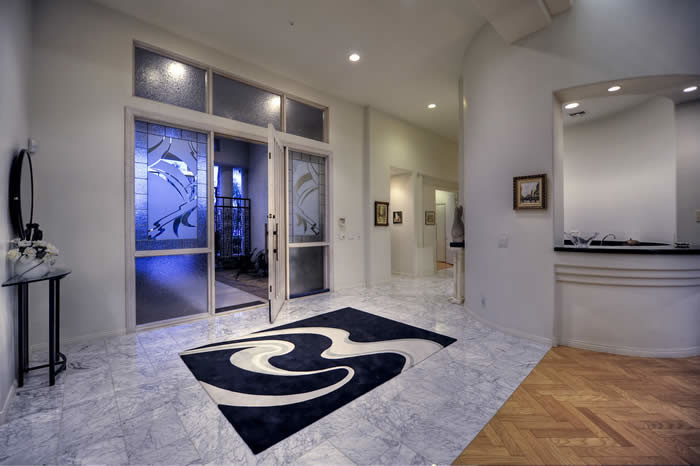 Inspiration for an expansive contemporary foyer in Phoenix with beige walls, travertine floors, a single front door and a glass front door.