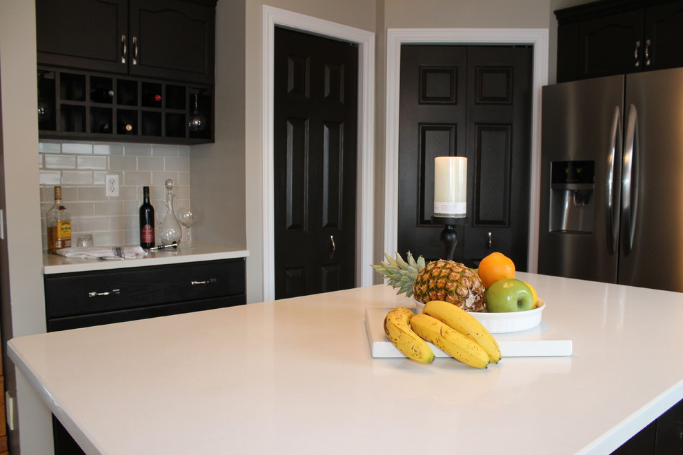Mid-sized transitional u-shaped medium tone wood floor open concept kitchen photo in Toronto with an undermount sink, recessed-panel cabinets, dark wood cabinets, quartzite countertops, gray backsplash, subway tile backsplash, stainless steel appliances and an island