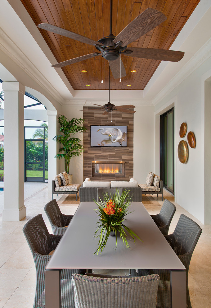 Transitional patio in Miami with a roof extension and with fireplace.