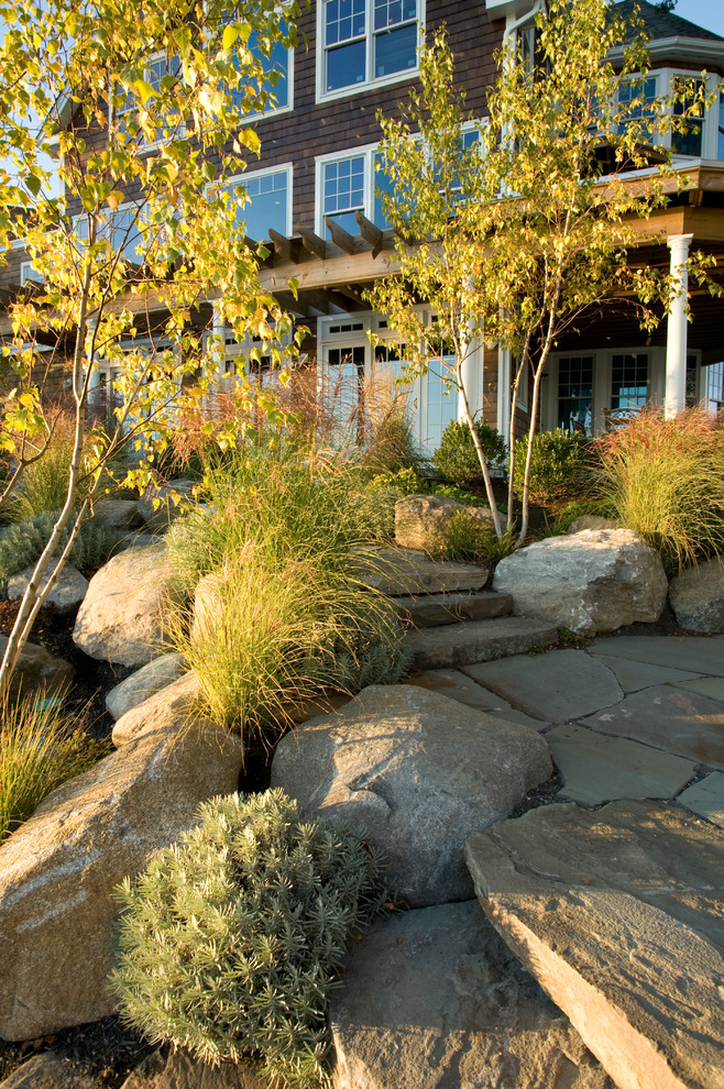 Photo of a large coastal full sun side yard stone landscaping in Boston with a fire pit.
