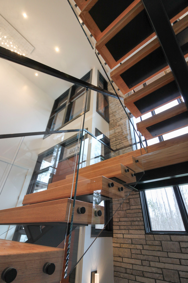 Cette image montre un grand escalier flottant minimaliste avec des marches en bois.