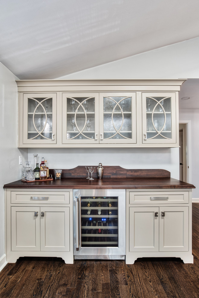 Design ideas for a mid-sized transitional single-wall wet bar in New York with beaded inset cabinets, beige cabinets, wood benchtops, painted wood floors, brown floor and brown benchtop.