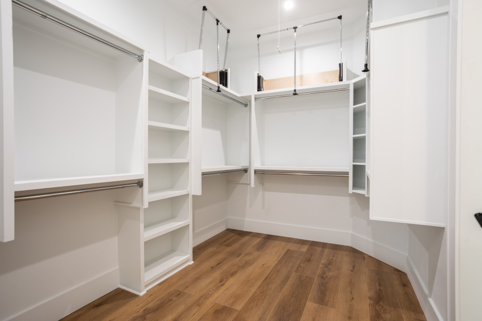 Idéer för att renovera ett mellanstort lantligt walk-in-closet för könsneutrala, med vinylgolv och brunt golv