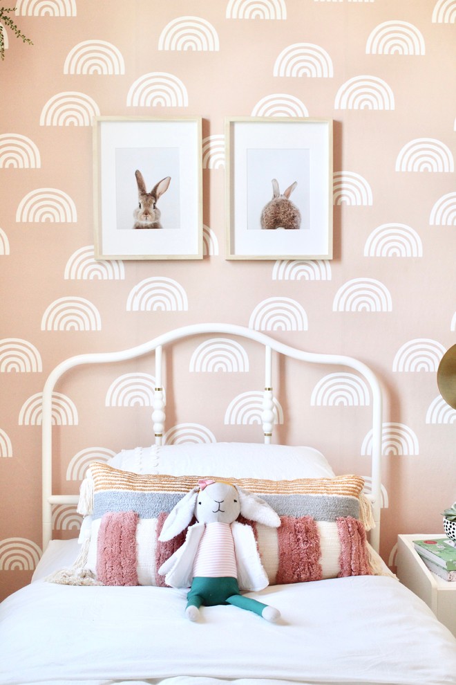 This is an example of a mid-sized transitional kids' bedroom for kids 4-10 years old and girls in Sacramento with pink walls, carpet and beige floor.