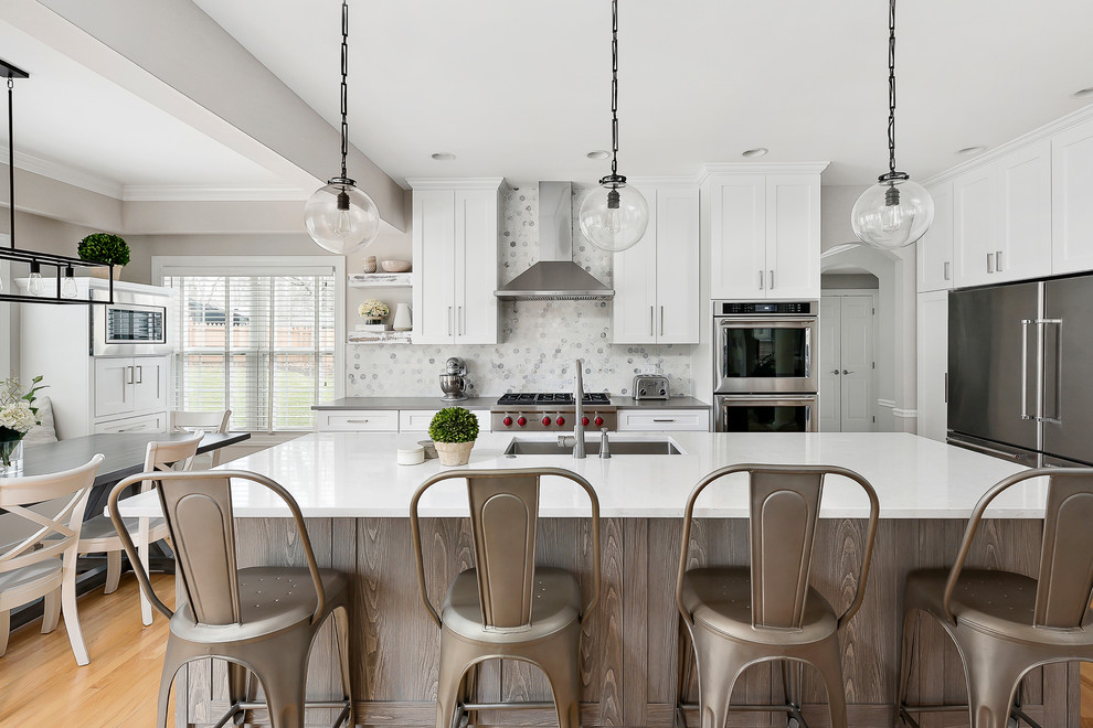 Example of a large transitional light wood floor open concept kitchen design in Chicago with an undermount sink, shaker cabinets, white cabinets, quartz countertops, gray backsplash, marble backsplash, stainless steel appliances and an island
