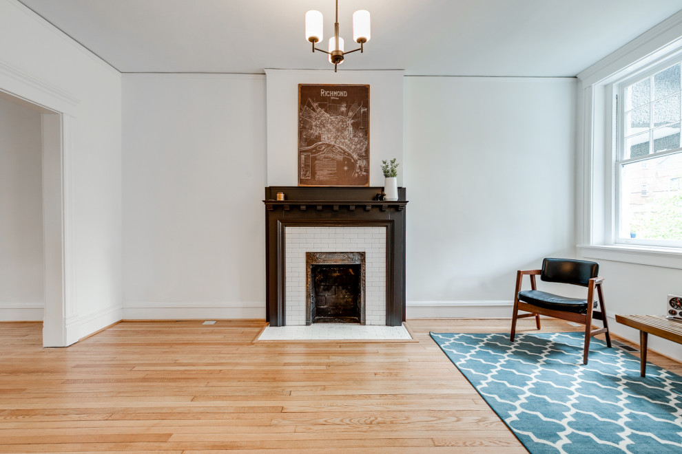Cette photo montre un salon chic de taille moyenne avec un mur blanc, parquet clair, une cheminée standard et un manteau de cheminée en carrelage.