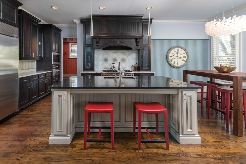 Inspiration for a traditional eat-in kitchen in Atlanta with an undermount sink, dark wood cabinets, multi-coloured splashback, stainless steel appliances, with island and dark hardwood floors.