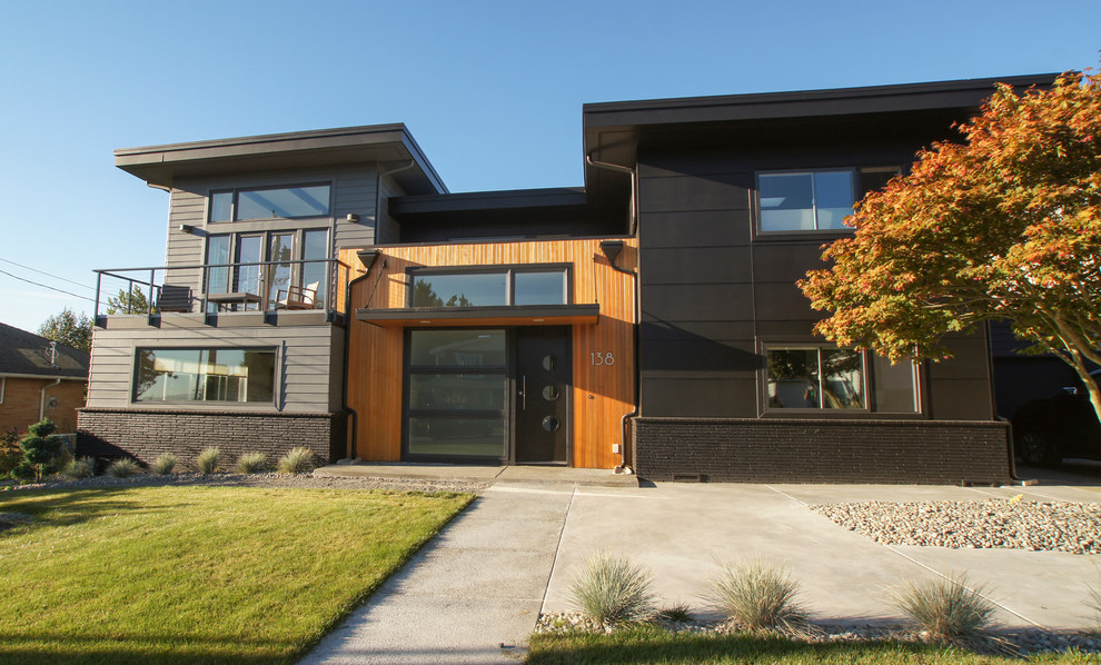 Photo of a large modern two-storey black exterior in Seattle with mixed siding and a flat roof.