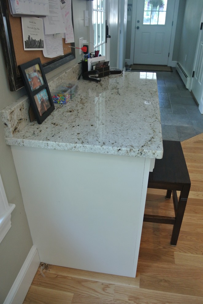Eat-in kitchen - transitional galley light wood floor eat-in kitchen idea in Boston with an undermount sink, shaker cabinets, white cabinets, wood countertops, white backsplash, ceramic backsplash, stainless steel appliances, an island and brown countertops