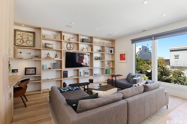 Small contemporary open concept living room in San Francisco with white walls, light hardwood floors, a corner fireplace, a stone fireplace surround, a built-in media wall and beige floor.