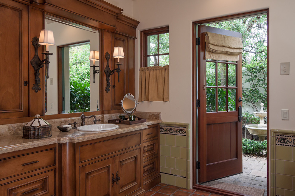 Mediterranean bathroom in Orange County with a drop-in sink, raised-panel cabinets and medium wood cabinets.