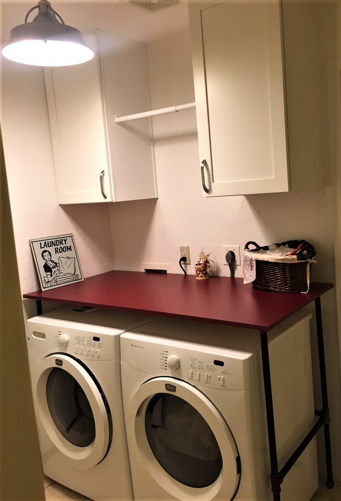 Photo of a small contemporary l-shaped utility room in Phoenix with shaker cabinets, white cabinets, laminate benchtops, yellow walls, porcelain floors and a side-by-side washer and dryer.