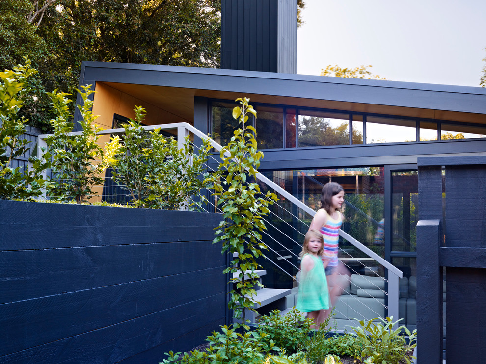 Large contemporary two-storey black exterior in Melbourne with metal siding and a gable roof.