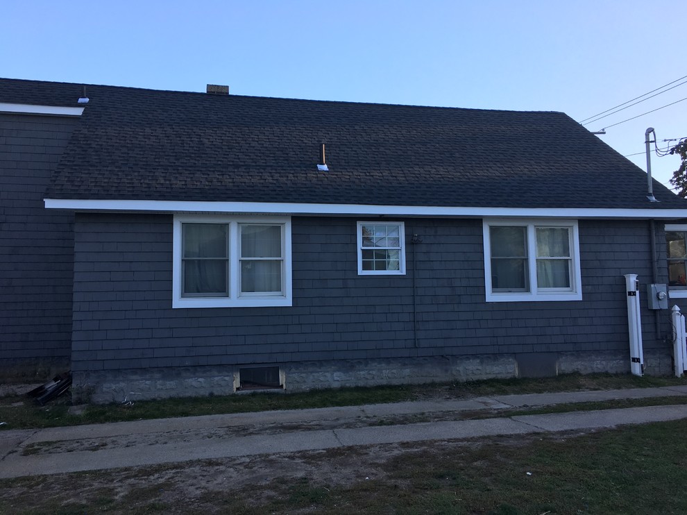 This is an example of a mid-sized country one-storey grey exterior in New York with wood siding and a gable roof.
