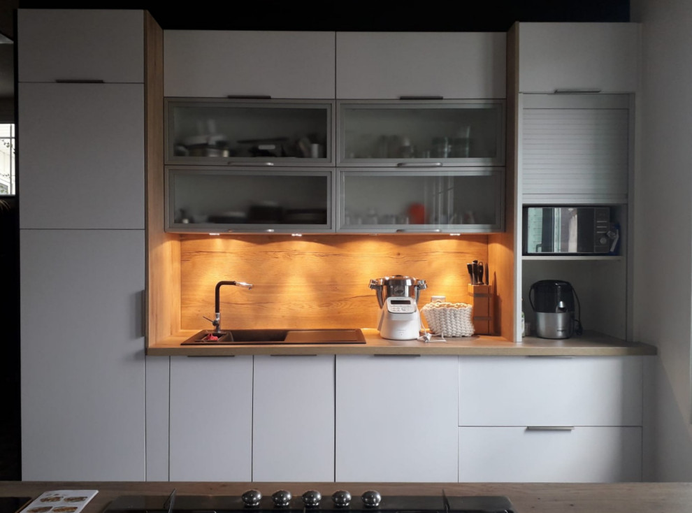 Inspiration for a small scandinavian galley open plan kitchen with an undermount sink, flat-panel cabinets, stainless steel cabinets, wood benchtops, brown splashback, timber splashback, stainless steel appliances, concrete floors, with island, grey floor, brown benchtop and wallpaper.