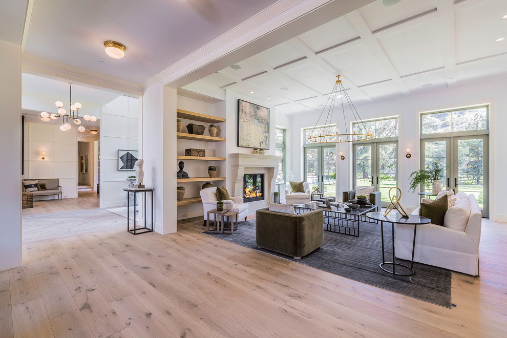 Expansive contemporary formal open concept living room in Los Angeles with white walls, light hardwood floors, a standard fireplace, a stone fireplace surround and grey floor.