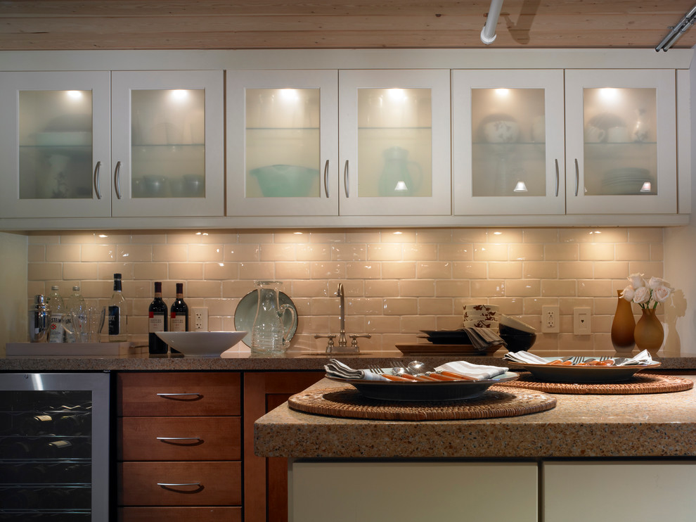 Transitional kitchen photo with flat-panel cabinets, white cabinets, granite countertops, beige backsplash, an island, an undermount sink, subway tile backsplash and stainless steel appliances