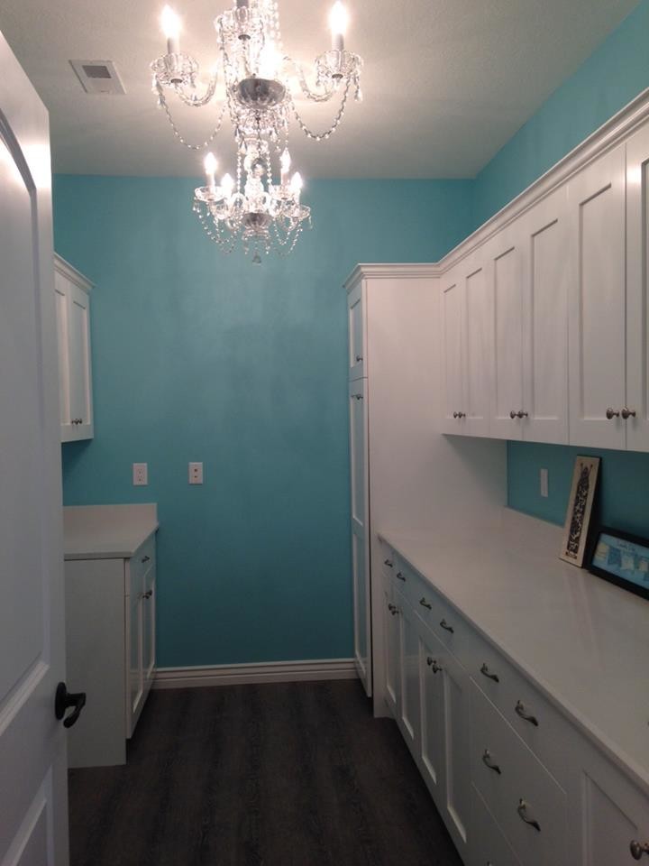 Design ideas for a mid-sized traditional galley dedicated laundry room in Denver with shaker cabinets, white cabinets, quartzite benchtops, blue walls, dark hardwood floors and brown floor.