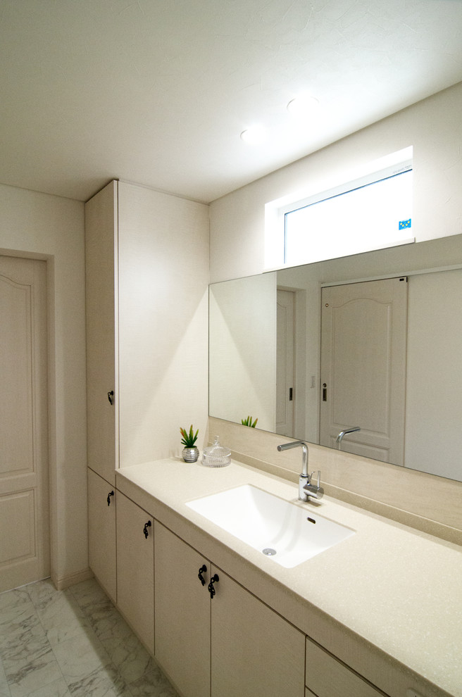 Photo of a modern powder room in Other with flat-panel cabinets, white cabinets, white walls, marble floors, an integrated sink and grey floor.