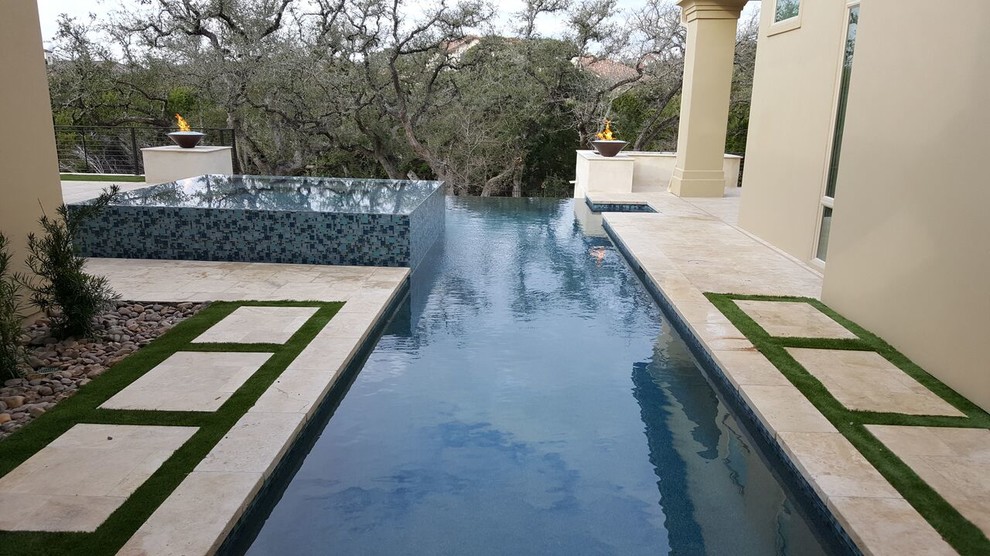Design ideas for a large modern backyard rectangular infinity pool in Austin with a hot tub and stamped concrete.