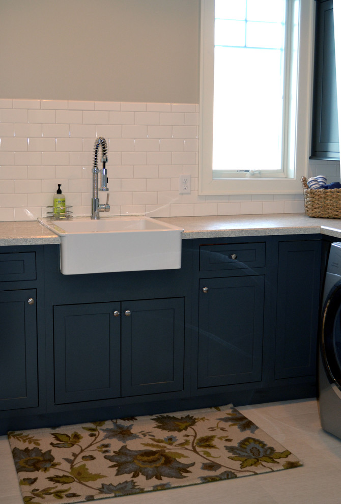 Large traditional l-shaped dedicated laundry room in Baltimore with a farmhouse sink, recessed-panel cabinets, laminate benchtops and a side-by-side washer and dryer.