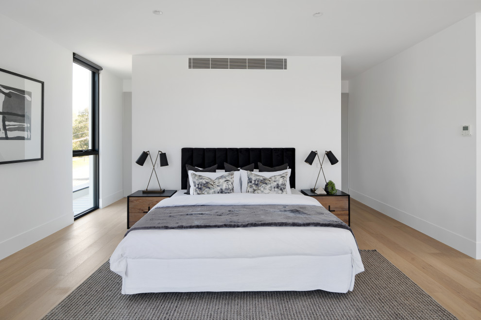 Design ideas for a contemporary bedroom in Melbourne with white walls, light hardwood floors and beige floor.