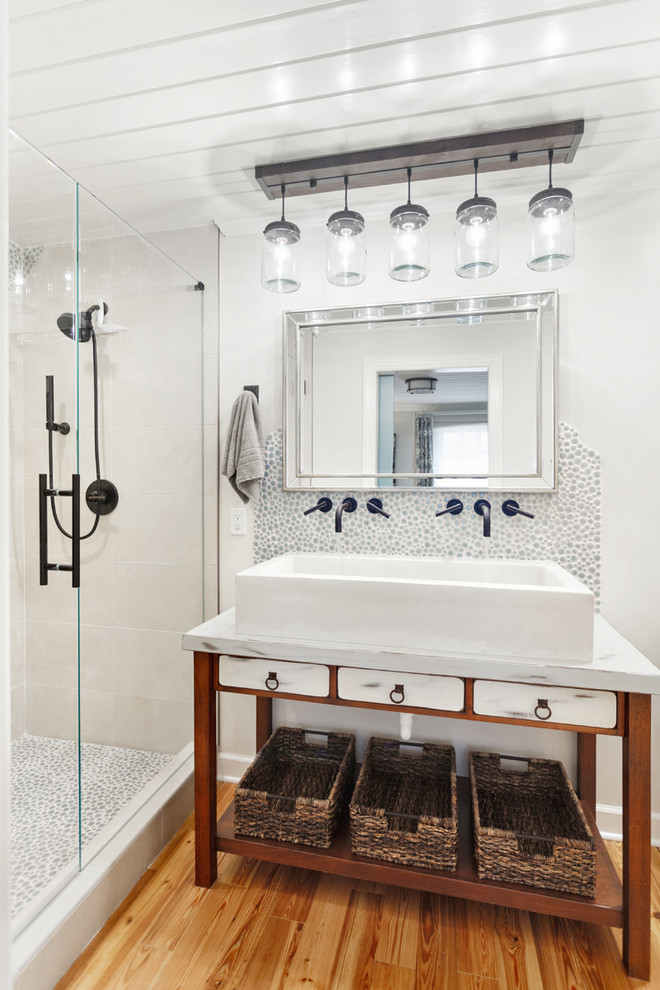 This is an example of a small country 3/4 bathroom in Charlotte with furniture-like cabinets, brown cabinets, an alcove shower, white tile, glass tile, white walls, medium hardwood floors, a vessel sink, marble benchtops, brown floor and a hinged shower door.