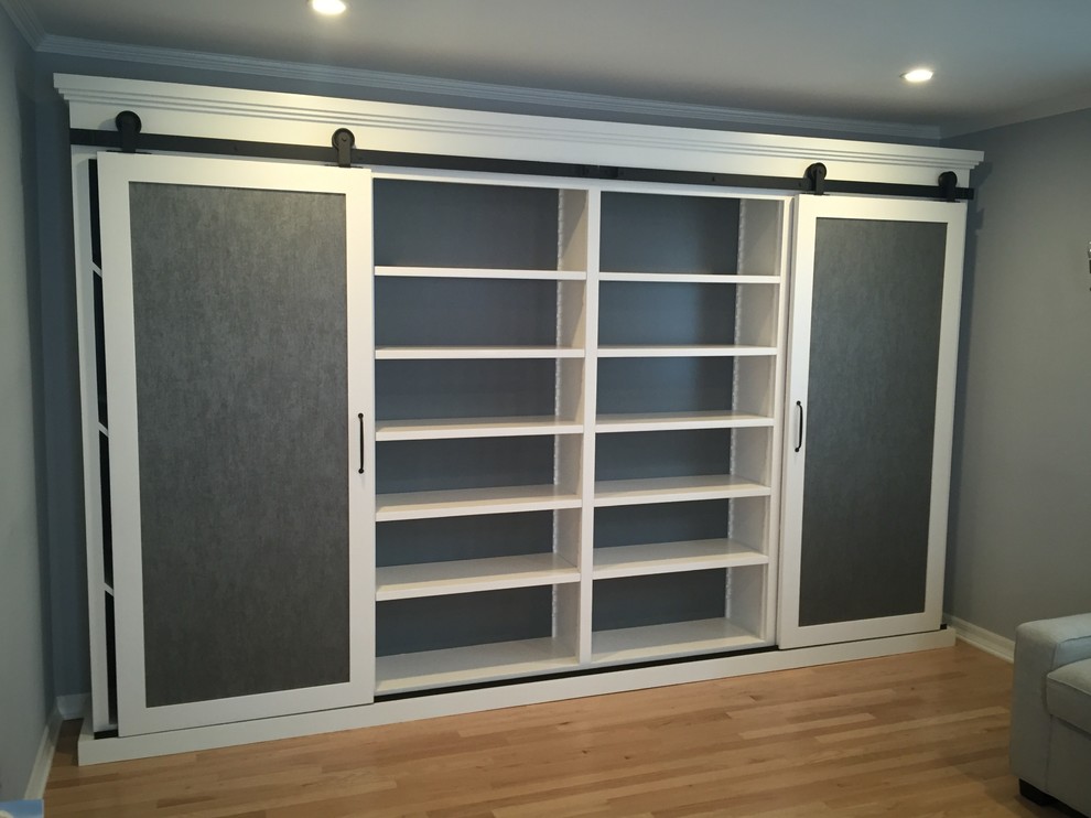 Photo of a mid-sized modern gender-neutral built-in wardrobe in Los Angeles with open cabinets, white cabinets and light hardwood floors.