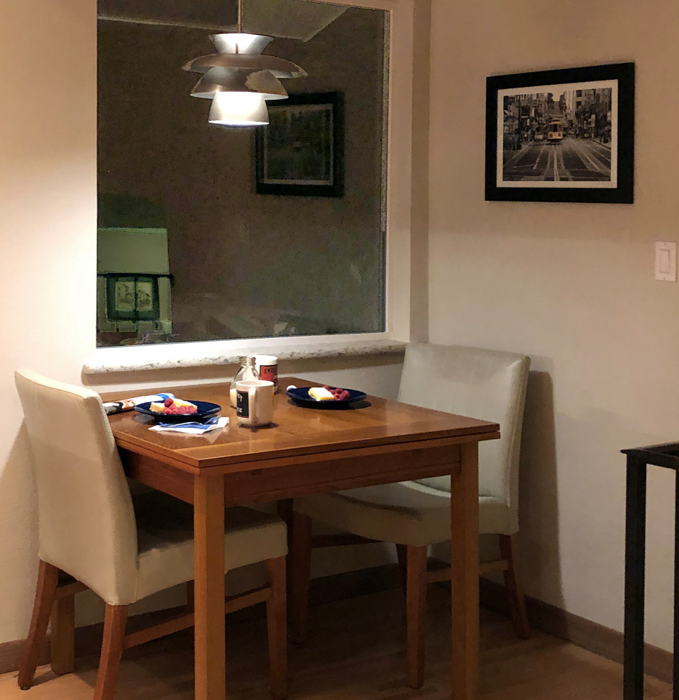 Cette photo montre une salle à manger ouverte sur la cuisine tendance de taille moyenne avec un sol en bois brun, un sol marron et poutres apparentes.