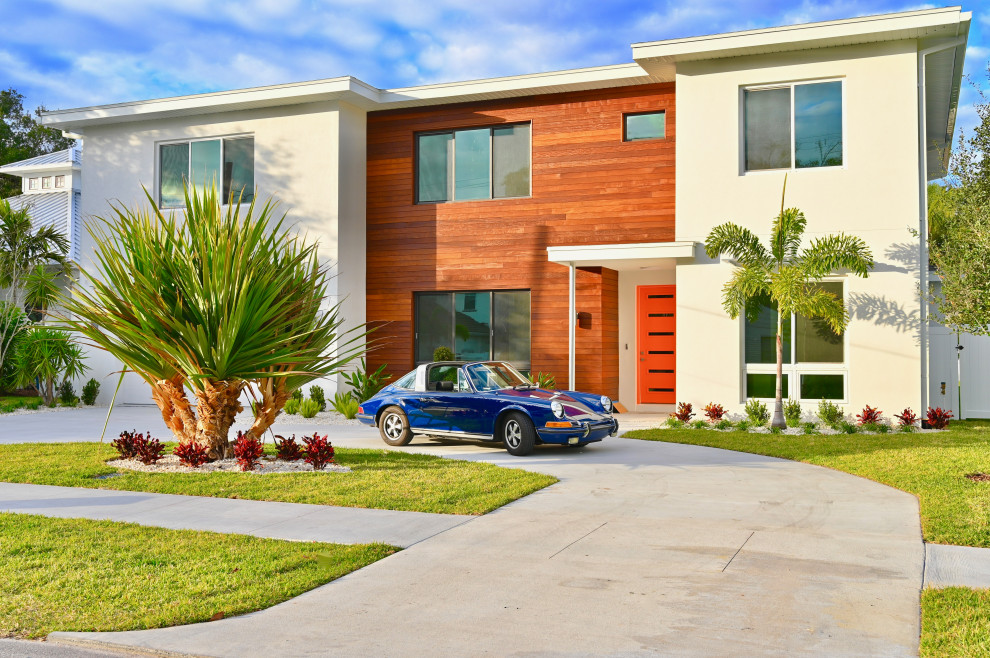 Large trendy white two-story wood house exterior photo in Tampa