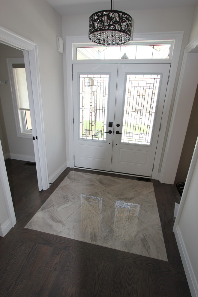 Mid-sized contemporary foyer in Toronto with beige walls, porcelain floors and grey floor.
