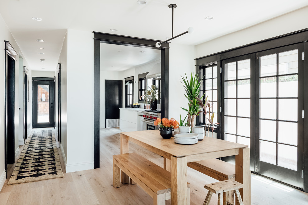 This is an example of a mid-sized beach style open plan dining in Los Angeles with white walls and light hardwood floors.