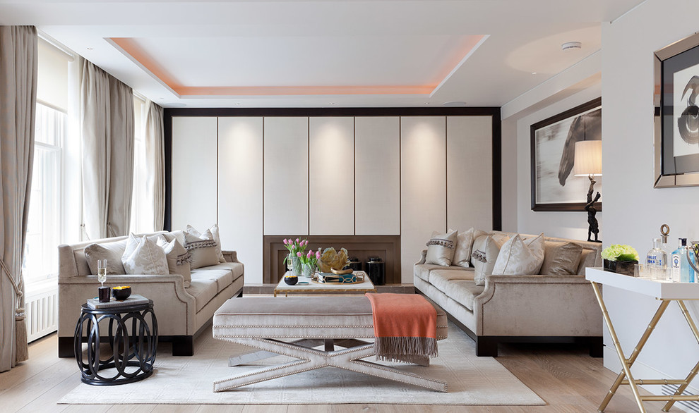 This is an example of a contemporary formal enclosed living room in London with beige walls and light hardwood floors.