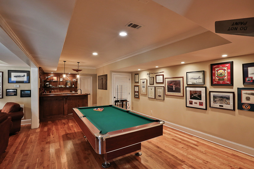 Photo of a large traditional walk-out basement in Atlanta with beige walls, medium hardwood floors and no fireplace.