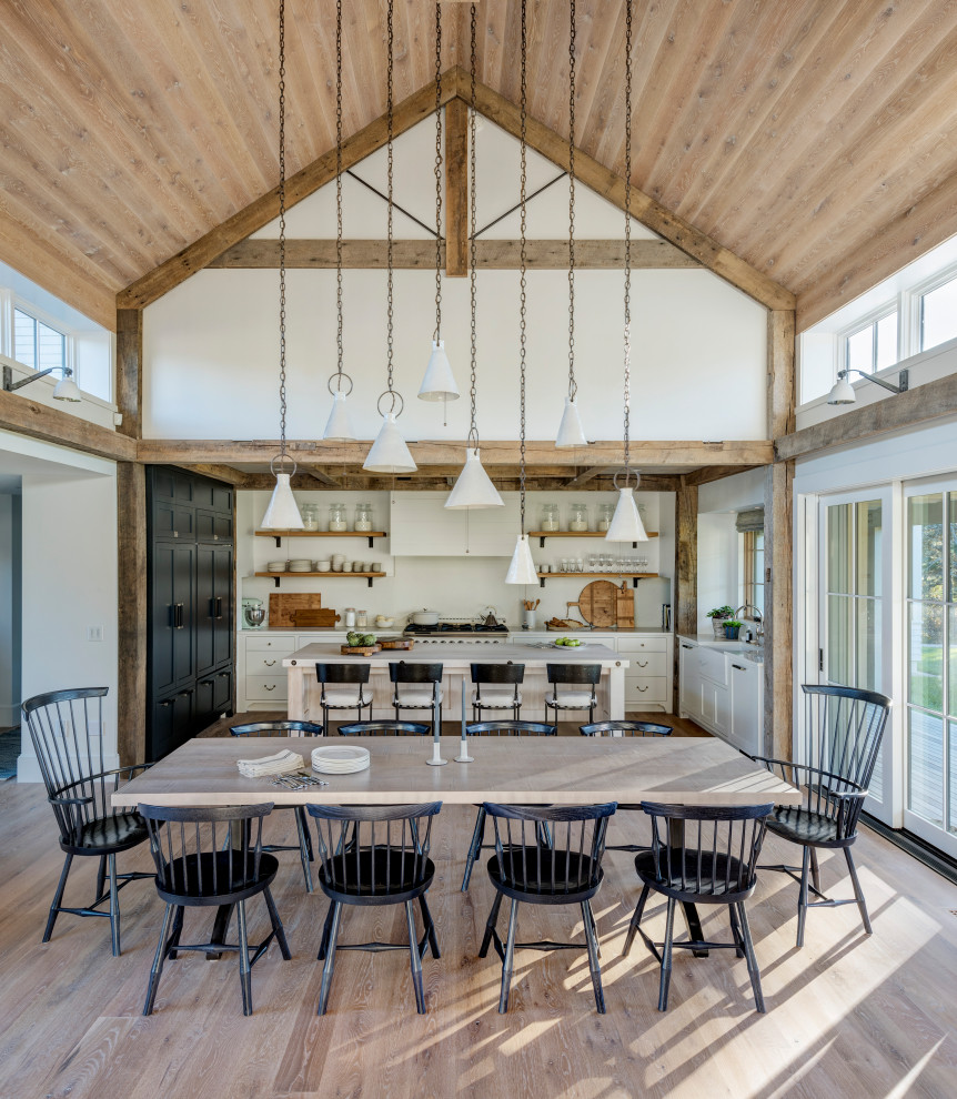 Country open plan dining in Boston with white walls, medium hardwood floors and brown floor.