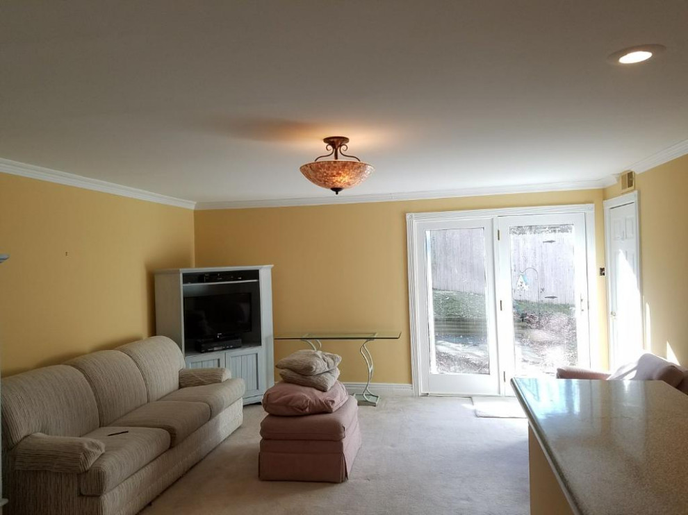 Cette photo montre un grand salon chic ouvert avec un mur jaune, moquette, aucune cheminée, un téléviseur d'angle, un sol gris et un plafond décaissé.