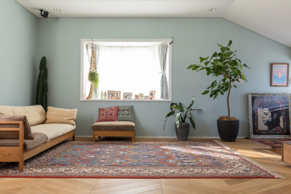 Foto di una sala da pranzo aperta verso il soggiorno stile rurale di medie dimensioni con pareti blu, parquet chiaro, pavimento beige e carta da parati