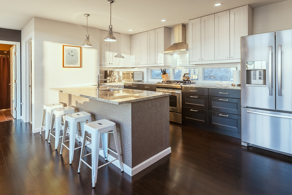 Example of a mid-sized transitional l-shaped dark wood floor and brown floor eat-in kitchen design in New York with an undermount sink, shaker cabinets, gray cabinets, granite countertops, window backsplash, an island, stainless steel appliances and multicolored countertops