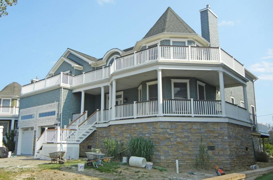 Design ideas for a large beach style two-storey blue exterior in New York with stone veneer.