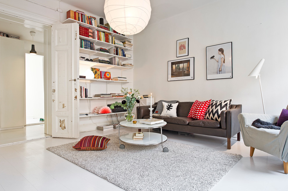 Photo of a scandinavian enclosed living room in Stockholm with white walls and painted wood floors.