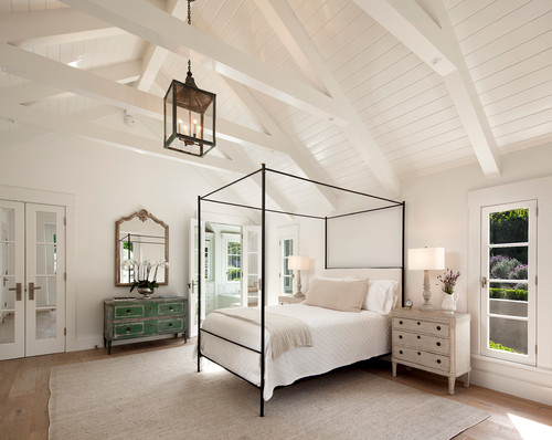 farmhouse bedroom with white wood exposed beams and white paneling 