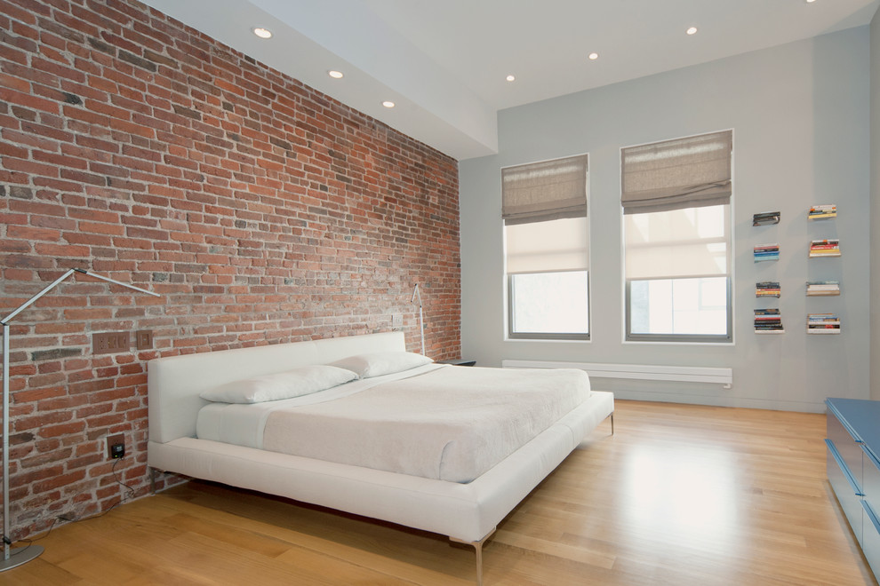 Design ideas for a contemporary bedroom in New York with light hardwood floors.
