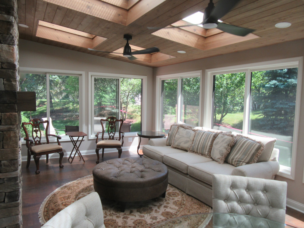 Photo of a mid-sized traditional sunroom in Chicago with ceramic floors, a standard fireplace, a skylight and brown floor.