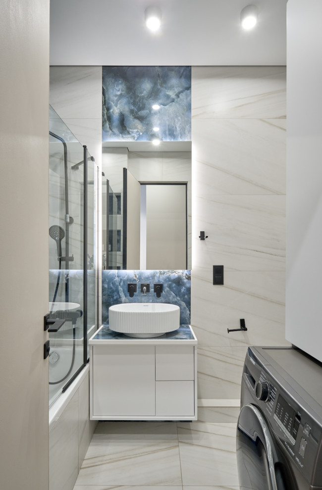 На фото: маленькая главная ванная комната со стиральной машиной в современном стиле с фасадами с декоративным кантом, белыми фасадами, полновстраиваемой ванной, душем над ванной, инсталляцией, керамогранитной плиткой, синими стенами, полом из керамогранита, накладной раковиной, столешницей из плитки, белым полом, душем с раздвижными дверями, зеркалом с подсветкой, нишей, тумбой под одну раковину и подвесной тумбой для на участке и в саду