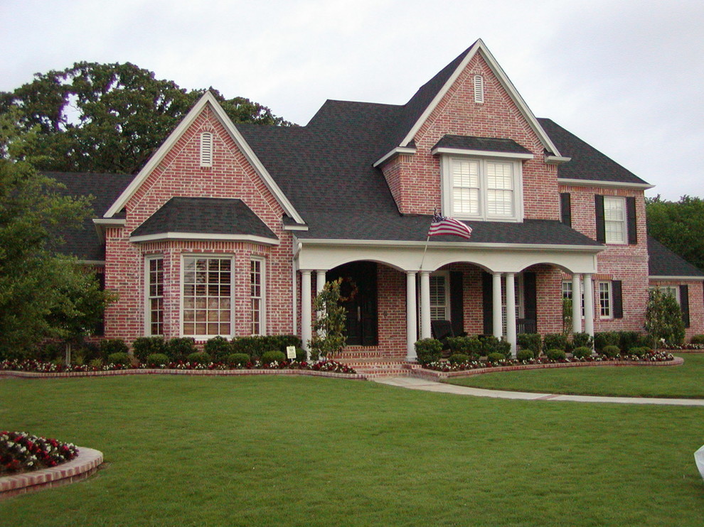 Inspiration for a traditional three-storey brown house exterior in Dallas with stone veneer.