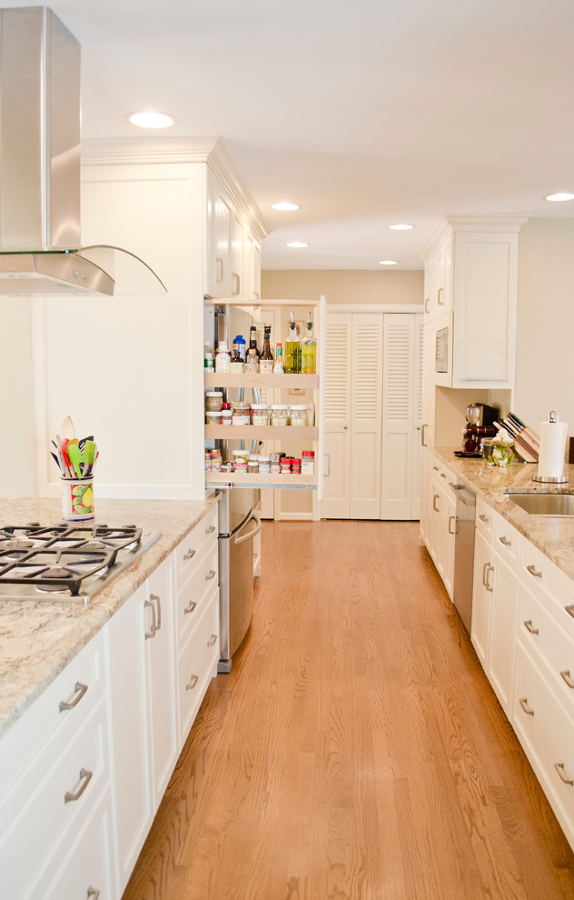Inspiration for a traditional galley kitchen in Philadelphia with an undermount sink, recessed-panel cabinets, white cabinets, stainless steel appliances and medium hardwood floors.